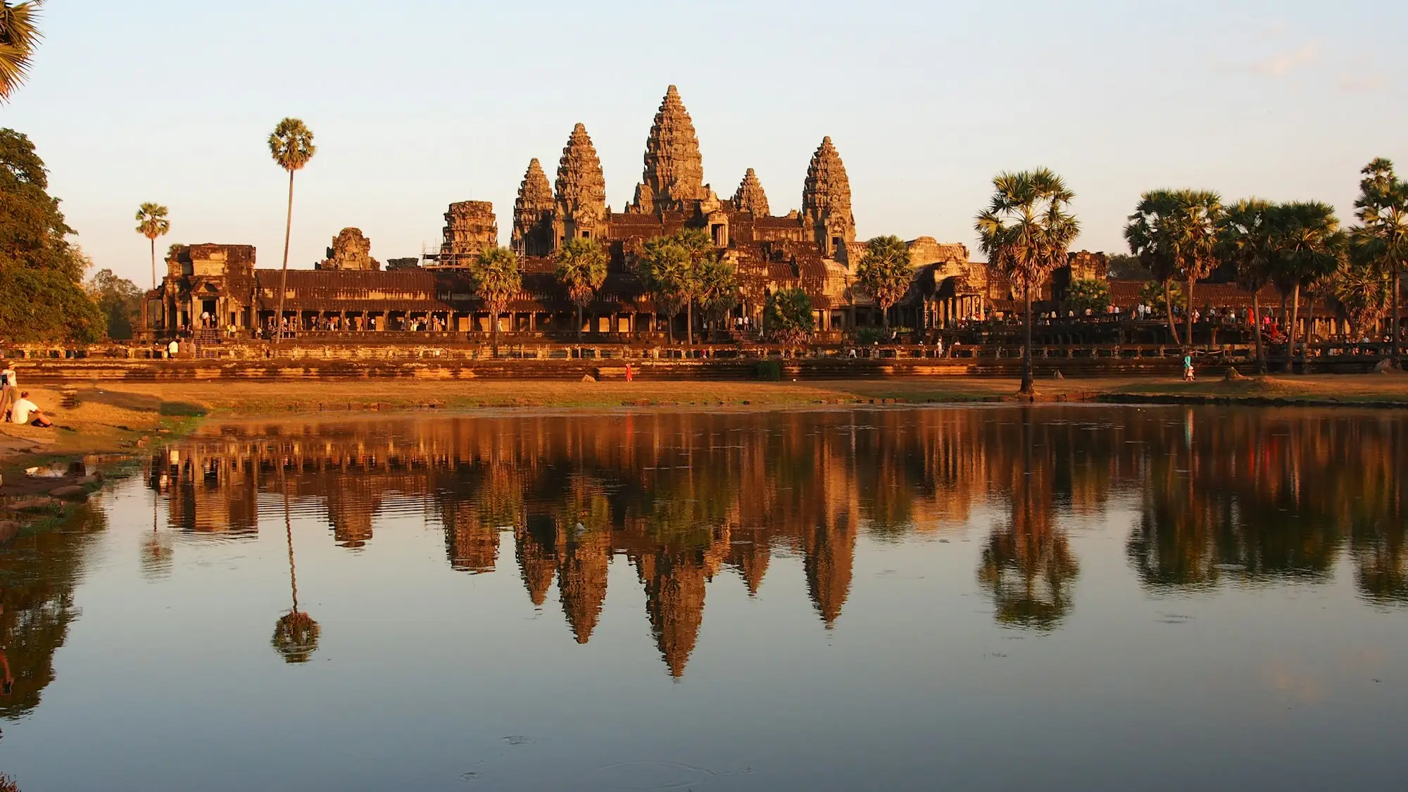 Angkor Wat temple towers reflected in the lotus pond at golden hour