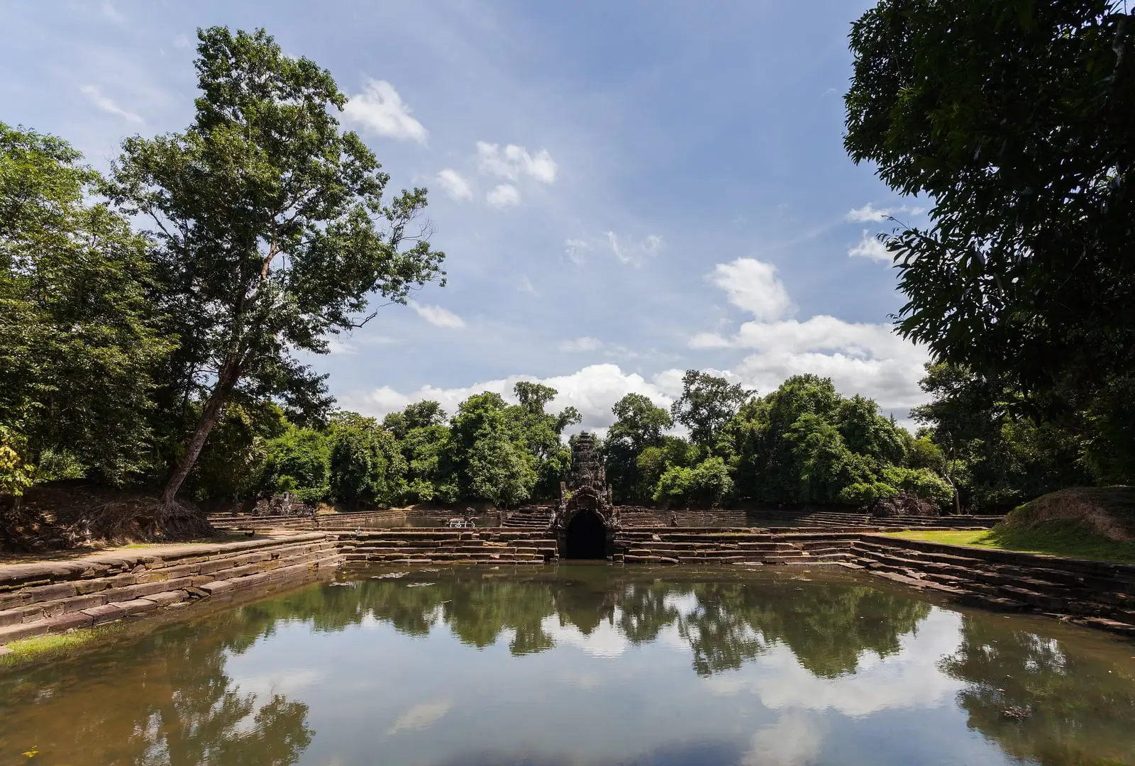 The circular stepped pool of Neak Pean with the small island shrine reflected in the calm water