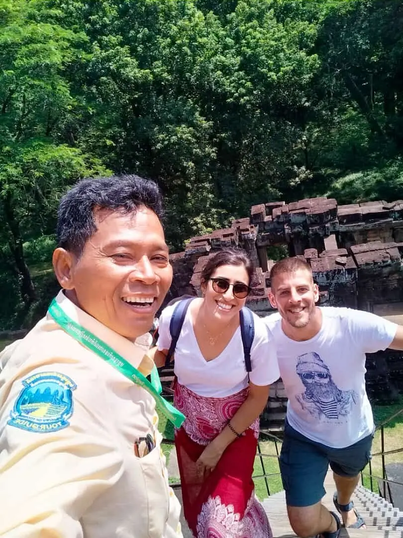 Licensed guide San wearing his guide badge with a young couple at a jungle temple