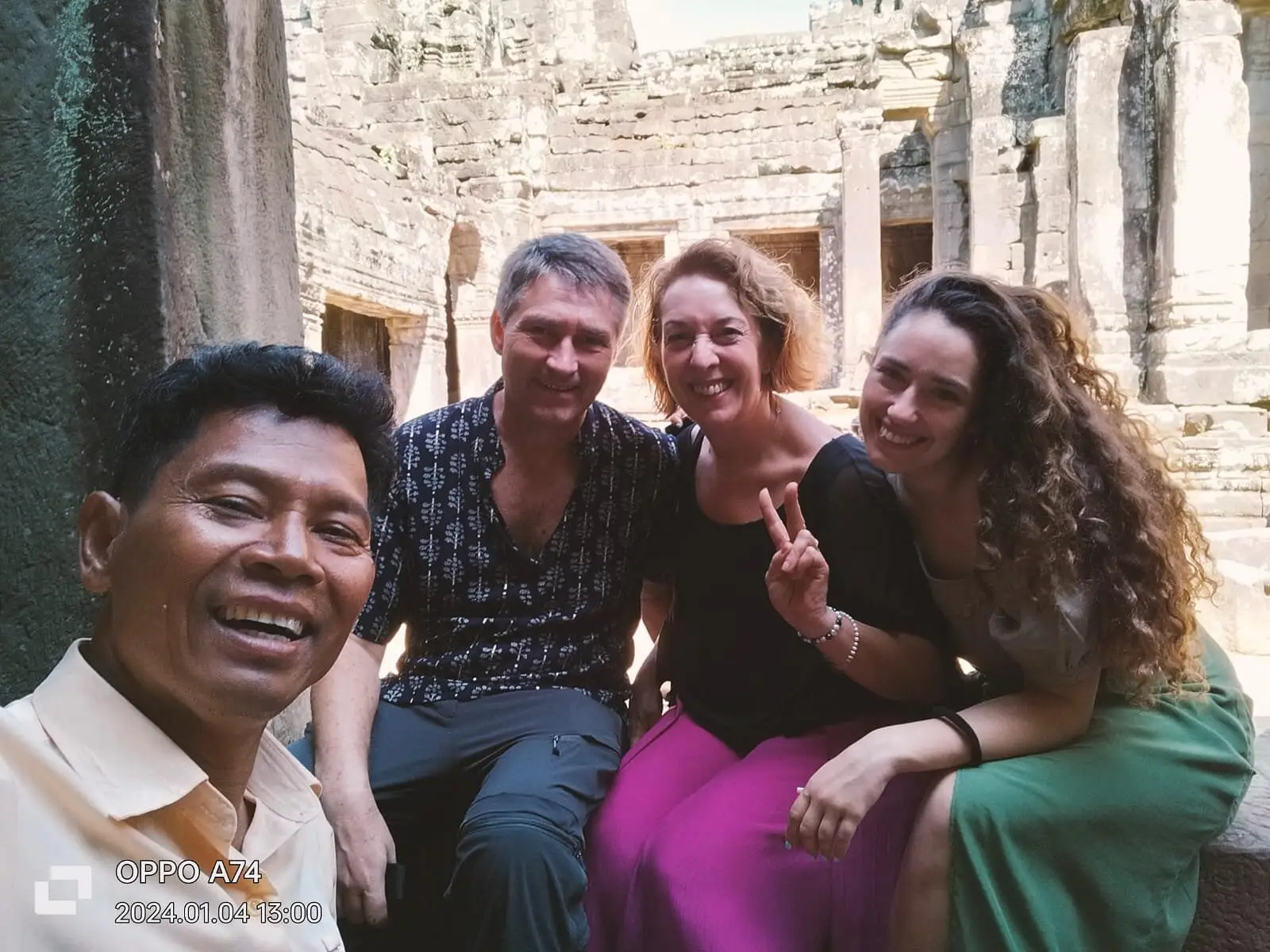 San with a family sitting on temple steps at Angkor