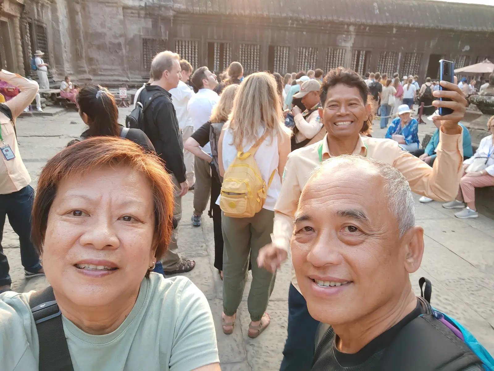 San with guests in the busy courtyard of Angkor Wat